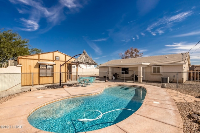 view of swimming pool featuring cooling unit and a patio area