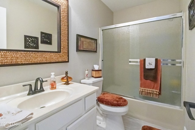 full bathroom with combined bath / shower with glass door, vanity, and toilet