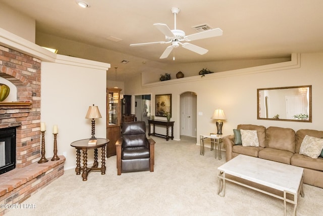 living room with light carpet, a fireplace, lofted ceiling, and ceiling fan