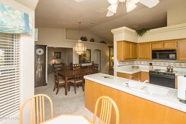 kitchen with lofted ceiling, tile countertops, light colored carpet, decorative backsplash, and black appliances