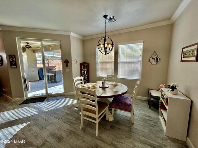 dining room with an inviting chandelier, crown molding, and dark hardwood / wood-style flooring