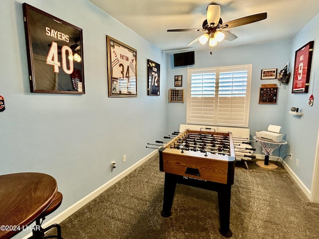 game room with ceiling fan and dark colored carpet