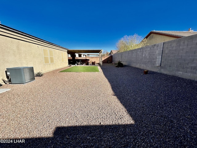 view of yard with central AC and a patio area