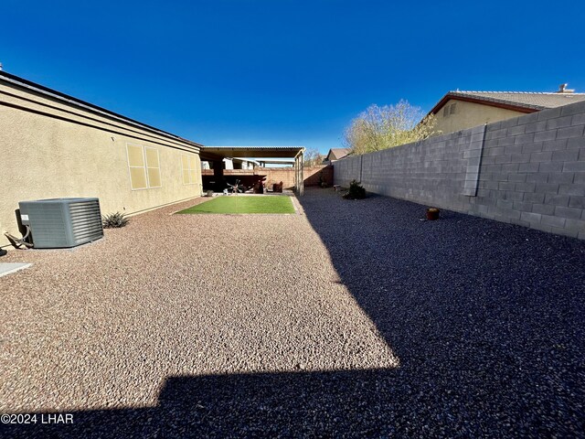 view of yard with central AC and a patio area