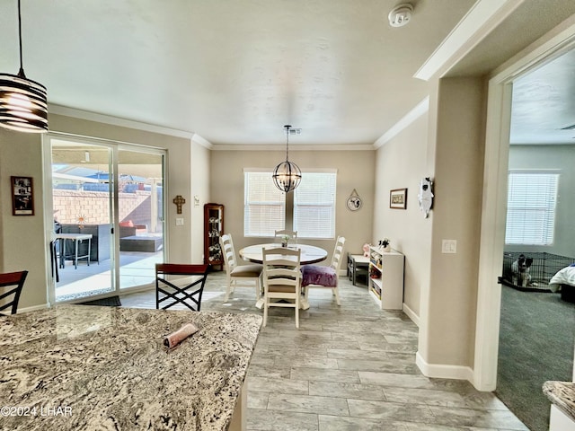 dining space with crown molding, a wealth of natural light, and a chandelier