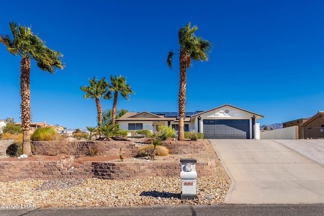 672 Wayside Dr, Lake Havasu City, AZ 86403 - single story home with driveway, an attached garage, roof mounted solar panels, fence, and stucco siding