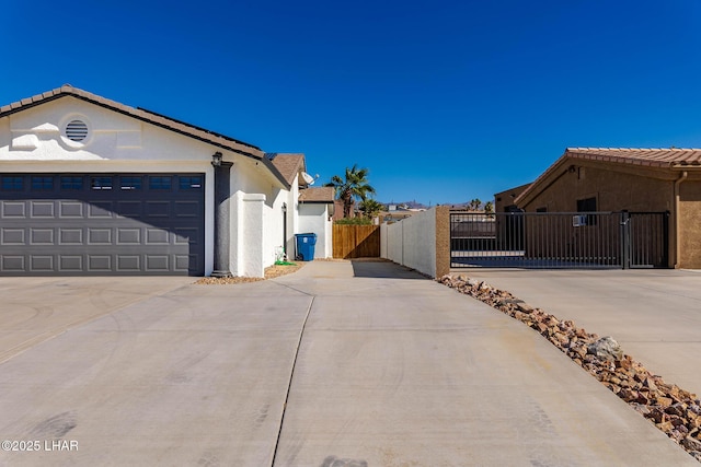 672 Wayside Dr, Lake Havasu City, AZ 86403 - view of property exterior with driveway, a gate, stucco siding, and an attached garage