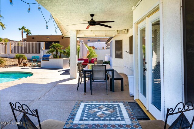 672 Wayside Dr, Lake Havasu City, AZ 86403 - view of patio / terrace featuring an outdoor kitchen, ceiling fan, fence, an outdoor pool, and outdoor dining area