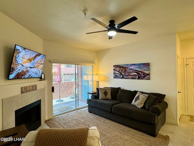 1650 S Smoketree Ave Unit 116, Lake Havasu City, AZ 86403 - living room featuring a ceiling fan, tile patterned floors, a tile fireplace, and a textured ceiling