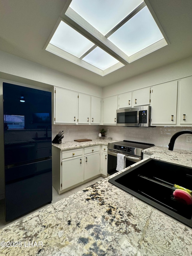 1650 S Smoketree Ave Unit 116, Lake Havasu City, AZ 86403 - kitchen with stainless steel appliances, tasteful backsplash, white cabinetry, and a sink