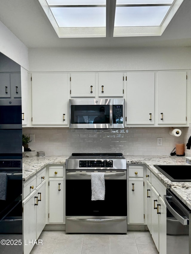 1650 S Smoketree Ave Unit 116, Lake Havasu City, AZ 86403 - kitchen featuring appliances with stainless steel finishes, light tile patterned floors, backsplash, and light stone counters
