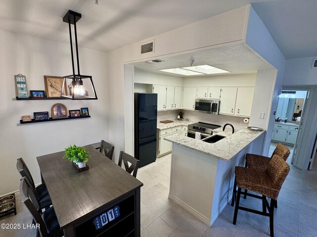 1650 S Smoketree Ave Unit 116, Lake Havasu City, AZ 86403 - kitchen with appliances with stainless steel finishes, a peninsula, a sink, light stone counters, and white cabinetry