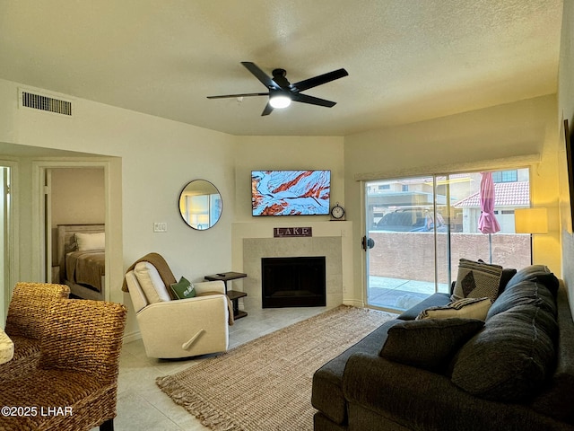 1650 S Smoketree Ave Unit 116, Lake Havasu City, AZ 86403 - living area with a tile fireplace, ceiling fan, light tile patterned floors, and a textured ceiling