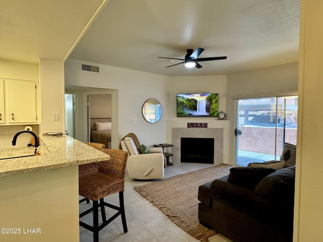 1650 S Smoketree Ave Unit 116, Lake Havasu City, AZ 86403 - living area with ceiling fan, a tiled fireplace, and light tile patterned flooring