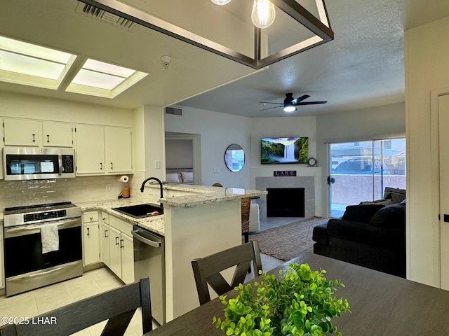 1650 S Smoketree Ave Unit 116, Lake Havasu City, AZ 86403 - kitchen with appliances with stainless steel finishes, a sink, a peninsula, backsplash, and open floor plan