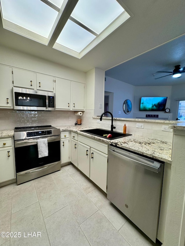 1650 S Smoketree Ave Unit 116, Lake Havasu City, AZ 86403 - kitchen featuring appliances with stainless steel finishes, a sink, tasteful backsplash, white cabinetry, and light tile patterned flooring