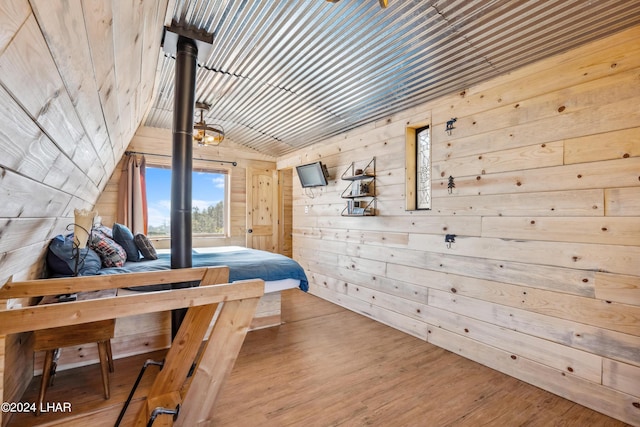 bedroom with hardwood / wood-style floors, wood ceiling, vaulted ceiling, and wood walls