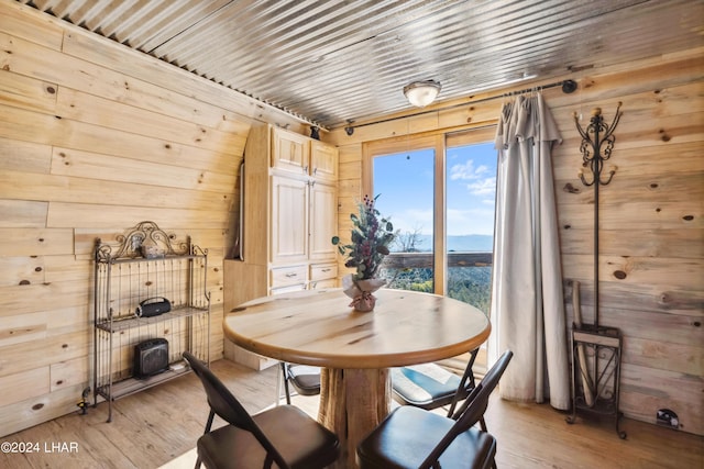 dining space featuring wood ceiling, wooden walls, and light hardwood / wood-style floors