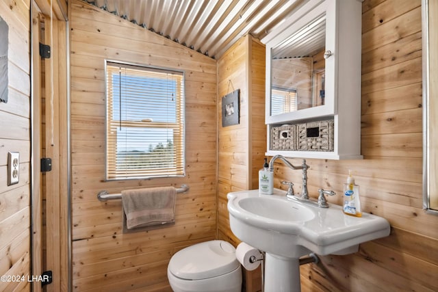 bathroom featuring wooden walls and toilet