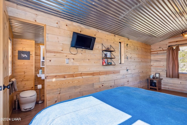 bedroom featuring hardwood / wood-style flooring, lofted ceiling, and wooden walls