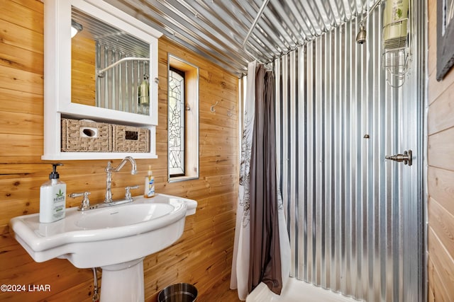 bathroom featuring sink and wood walls