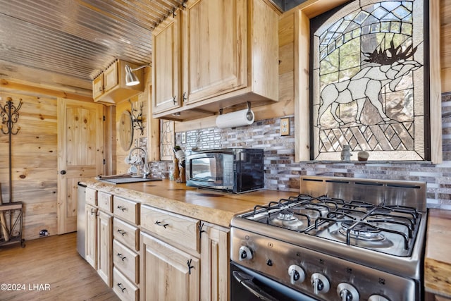 kitchen featuring gas range, sink, and light brown cabinets