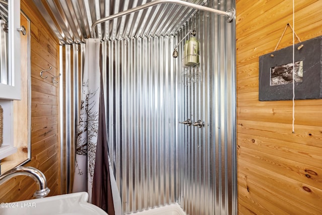 bathroom featuring sink and wood walls