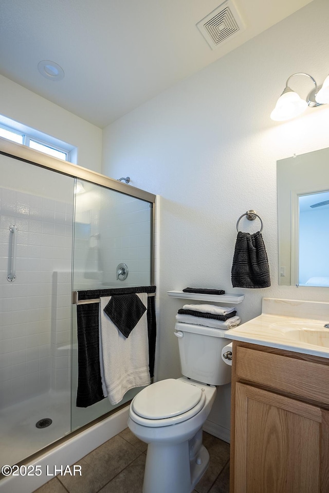 bathroom featuring vanity, tile patterned floors, a shower with door, and toilet