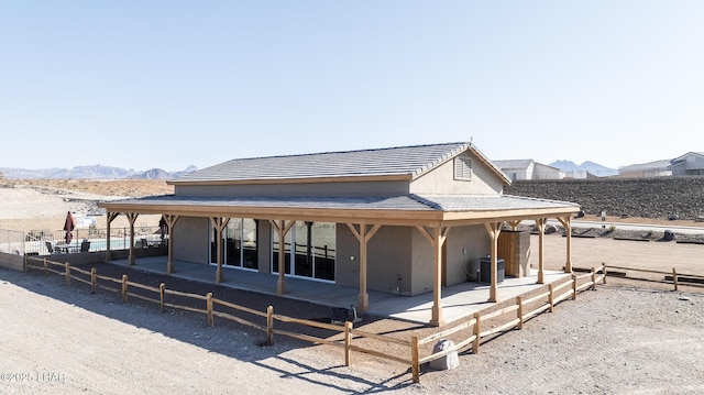 back of property with a mountain view and central air condition unit