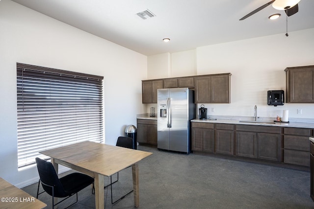 kitchen with dark brown cabinetry, sink, ceiling fan, and stainless steel refrigerator with ice dispenser