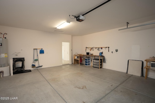 garage with a workshop area, a garage door opener, and water heater