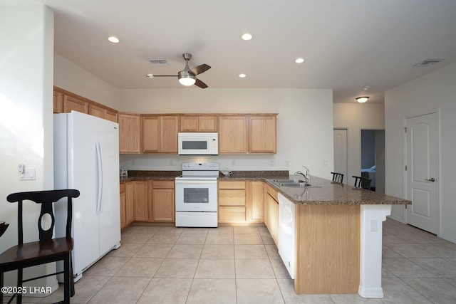 kitchen featuring light brown cabinetry, sink, kitchen peninsula, white appliances, and dark stone counters