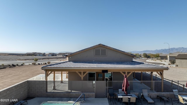 back of house featuring a mountain view and a patio area