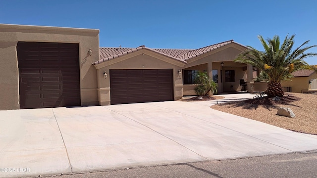 2930 Poseidon Ln, Lake Havasu City, AZ 86404 - view of front facade with a garage, stucco siding, concrete driveway, and a tiled roof