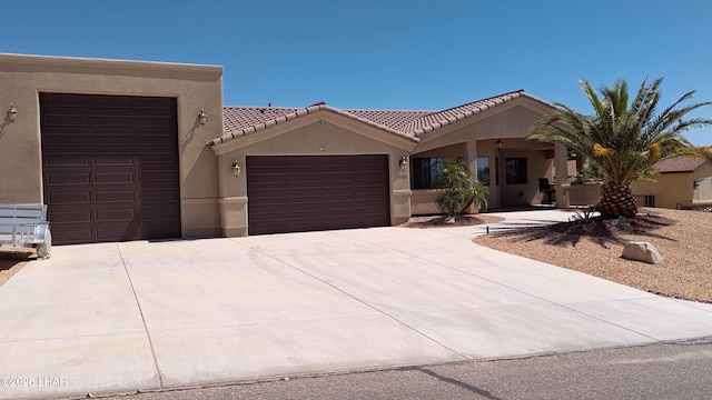 2930 Poseidon Ln, Lake Havasu City, AZ 86404 - view of front of home with an attached garage, concrete driveway, stucco siding, and a tiled roof