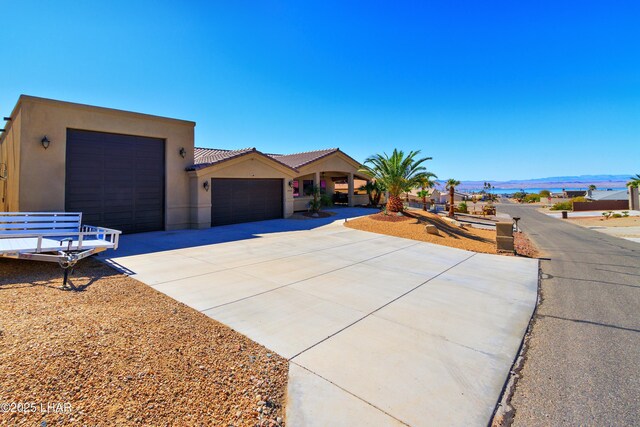 2930 Poseidon Ln, Lake Havasu City, AZ 86404 - view of front of house featuring a garage, driveway, stucco siding, and a tile roof
