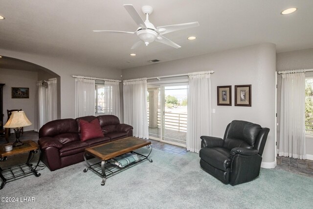 carpeted living room with ceiling fan and plenty of natural light