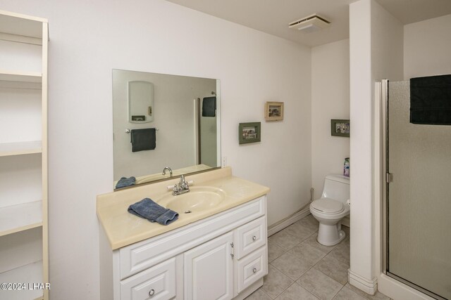 bathroom featuring vanity, tile patterned floors, toilet, and walk in shower