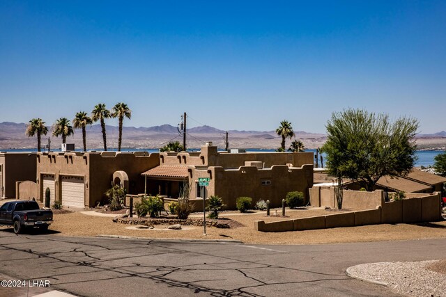 adobe home featuring a mountain view and a garage