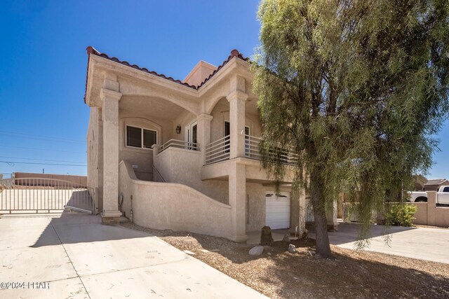 view of front of property featuring a garage and a balcony