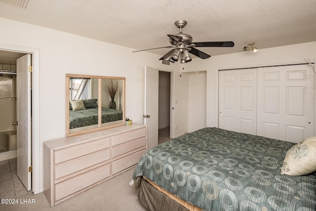 carpeted bedroom featuring a closet, a ceiling fan, and a textured ceiling