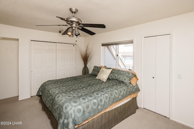 bedroom featuring a ceiling fan, carpet flooring, and two closets
