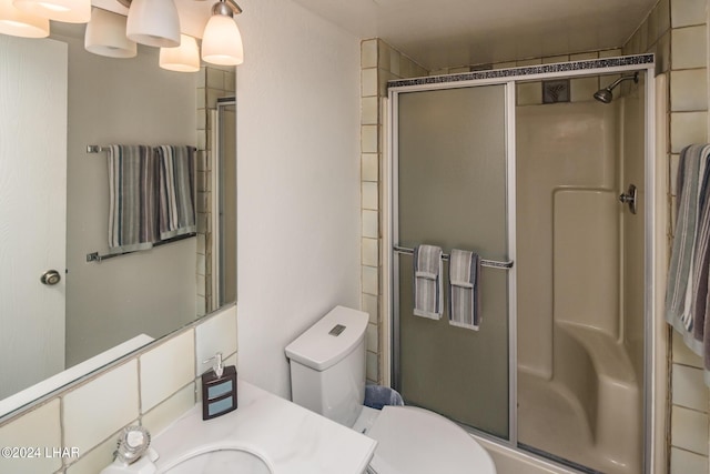 full bathroom with toilet, a shower stall, and vanity