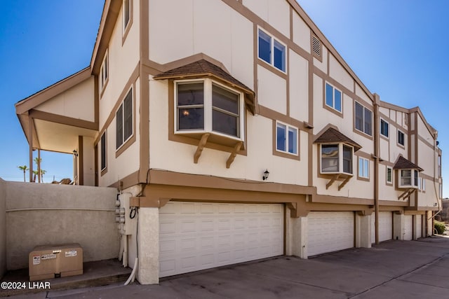view of front facade with an attached garage, concrete driveway, and stucco siding