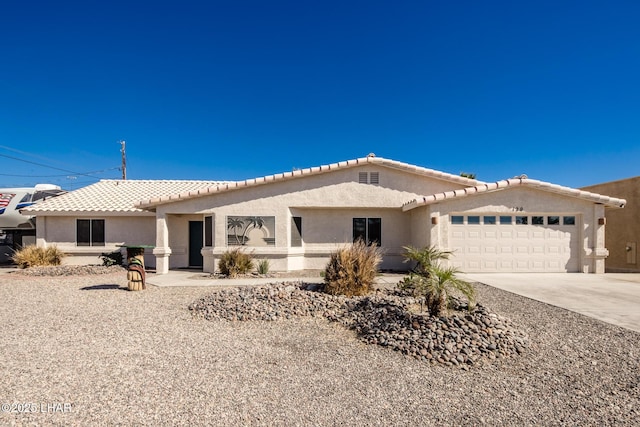 view of front of house with driveway, an attached garage, a tile roof, and stucco siding