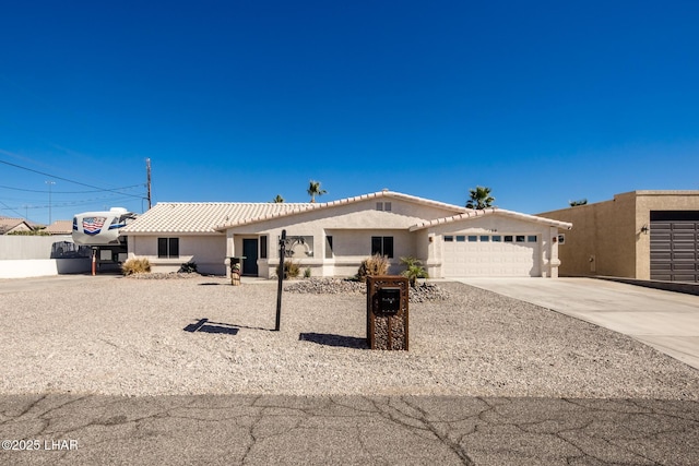 single story home with an attached garage, a tile roof, concrete driveway, and stucco siding