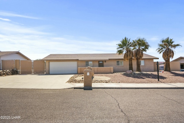 single story home with concrete driveway, stucco siding, fence, and an attached garage