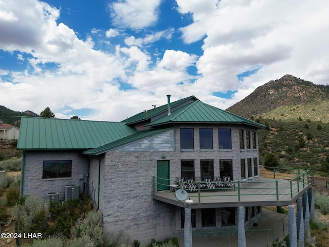 view of side of home featuring central AC unit, a mountain view, and a balcony