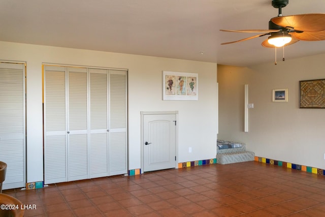 unfurnished bedroom with ceiling fan and dark tile patterned floors