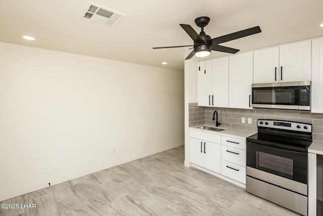 kitchen featuring stainless steel appliances, a sink, visible vents, light countertops, and backsplash